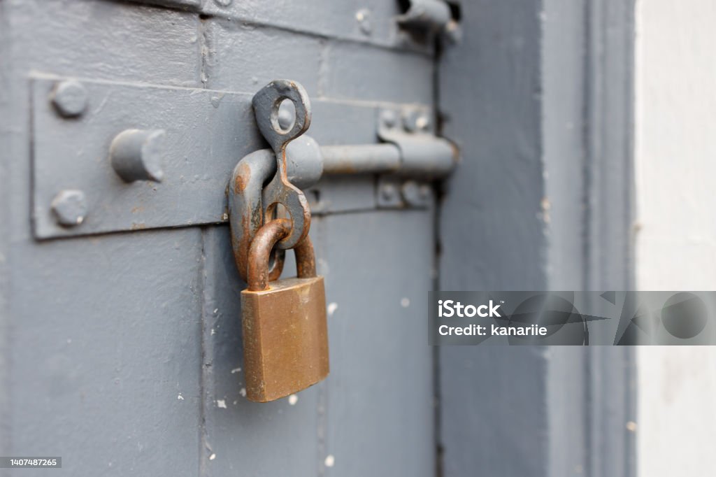 Old rusty padlock on a door Old, rusty padlock on a gray wooden door. Abstract Stock Photo