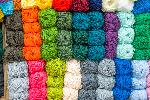 Colourful handmade rugs piled up on display at central market, South Australia