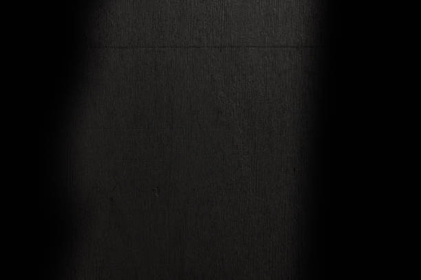 Close up on a wooden panel black wall.