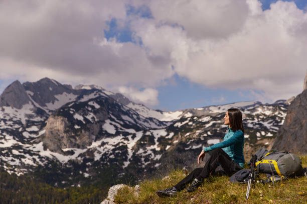 istock Female hiker with backpack relaxing and enjoying the view 1407494802