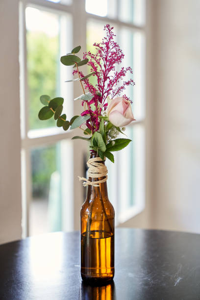 decoração com flores em uma garrafa de cerveja - copo pequeno para bebida alcoólica - fotografias e filmes do acervo