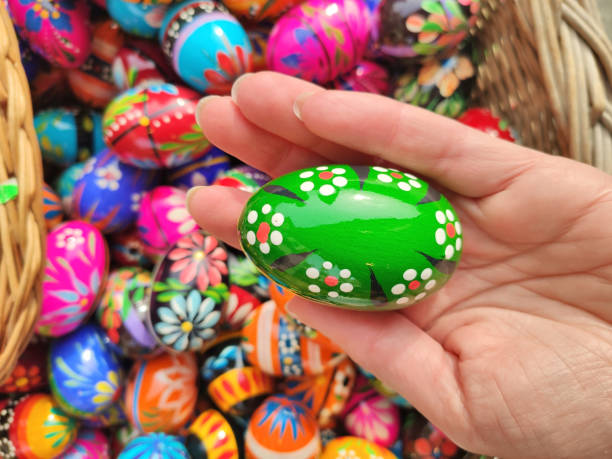 istock Green decorated Easter egg in hand on traditional Easter market in Krakow 1407497389