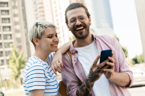 istock Portrait of a happy young couple using smartphone and having fun 1407500236
