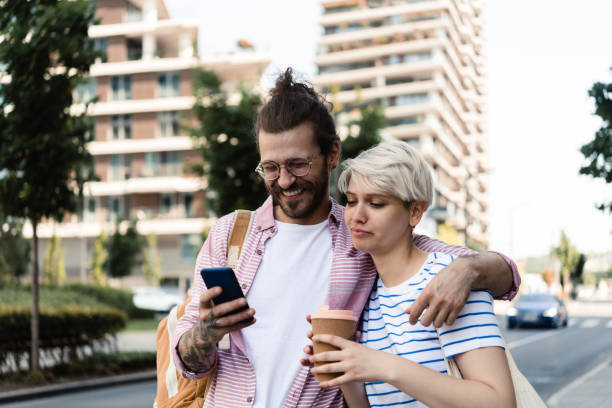istock Portrait of a young, hipster couple using smartphone on the move 1407500249