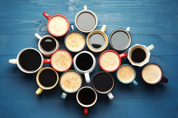 istock Many cups of different coffee drinks on blue wooden table, flat lay 1407501280