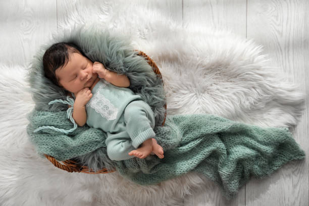istock Cute newborn baby sleeping in wicker basket, top view 1407501387