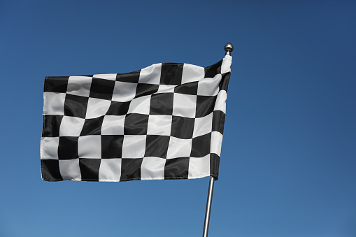 Checkered finish flag on light blue background