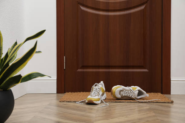 Stylish shoes on door mat in hall Stylish shoes on door mat in hall running shoes on floor stock pictures, royalty-free photos & images