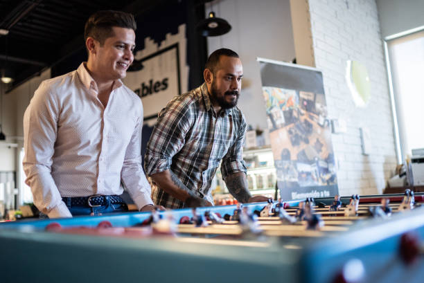 Coworkers playing in a foosball table