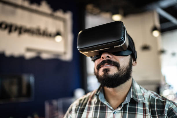 Mid adult man using a virtual reality glasses in the office