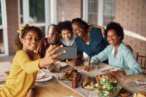 istock Happy black multi-generation family taking selfie during lunch at dining table. 1407511316