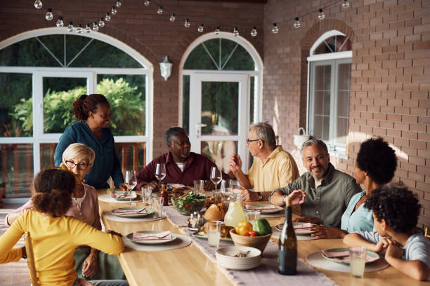 istock Multiethnic extended family talking during meal at dining table on a patio. 1407511381