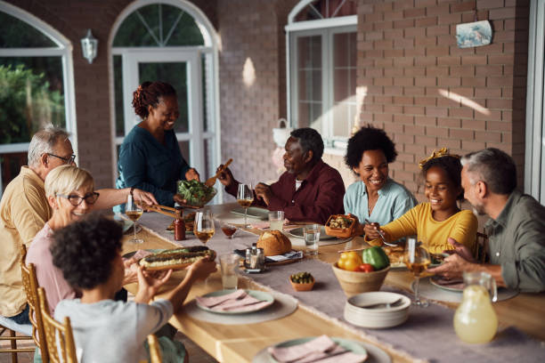 istock Happy multiracial family having lunch at dining table on patio. 1407511459