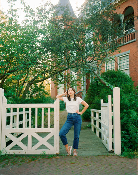 Young Caucasian woman standing in the gateway near the house