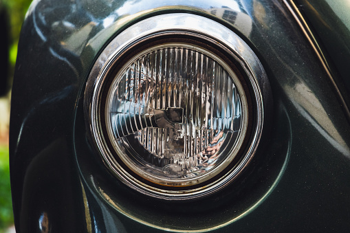 Classic old round headlight. Old timer car details. Close up photo with soft selective focus