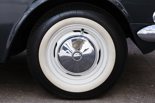 Closeup photo of white wheel of a car parked on a road