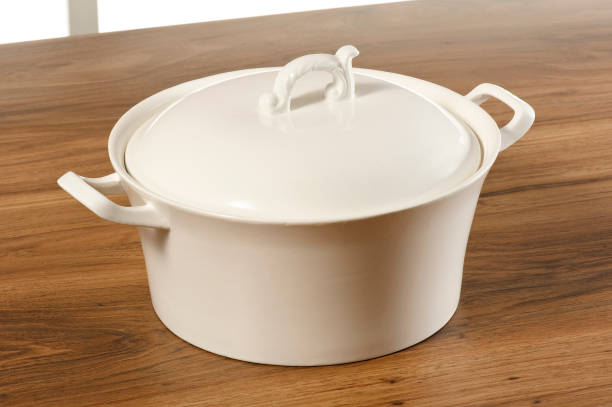 istock Beige ceramic pot with lid, on a wooden table 1407513685