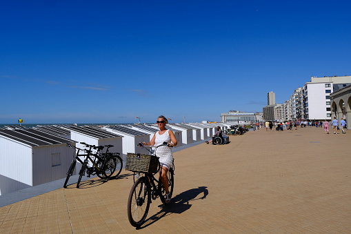 A cyclist rides her bike in Ostend, Belgium on Jul. 3, 2022.Ostend is a city on the Belgian coast. It's known for its long beach and promenade.