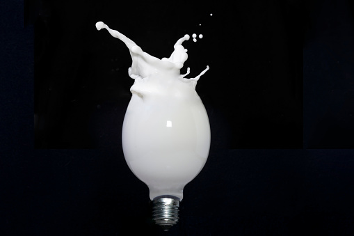 Milk splash in a light bulb, isolated on black