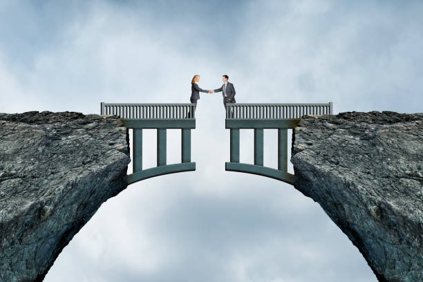 istock Man And Woman Shaking Hands Across Bridge Separation 1407521500