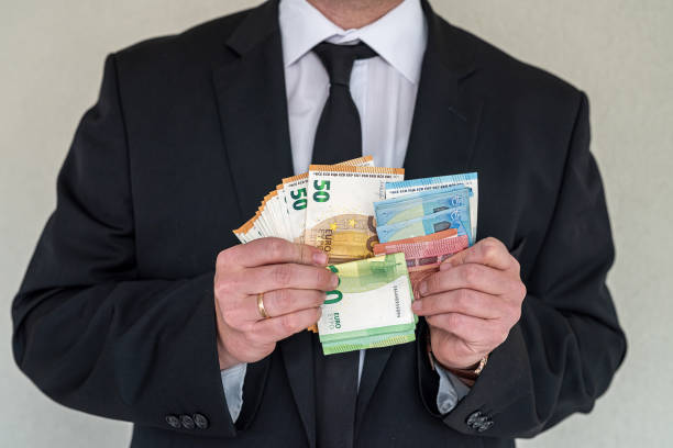 istock Business man in suit counts euro banknotes at work. 1407523741