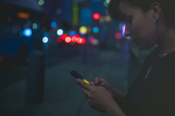 istock Woman using smartphone at night in the city 1407525422