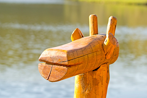 wooden horse in front of the lake