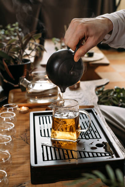 istock Traditional tea ceremony - pouring chinese oolong in glass cup 1407526812
