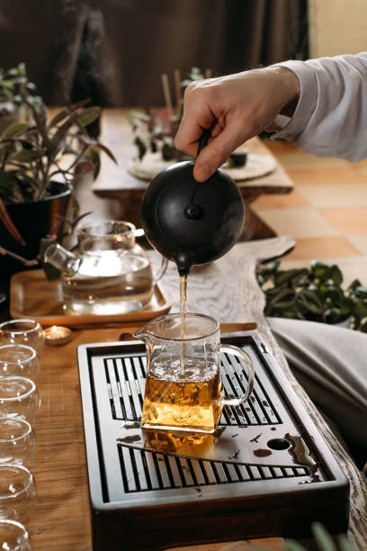 istock Traditional tea ceremony - pouring chinese oolong in glass cup 1407527740