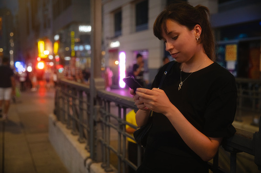 Woman using smartphone at night in the city