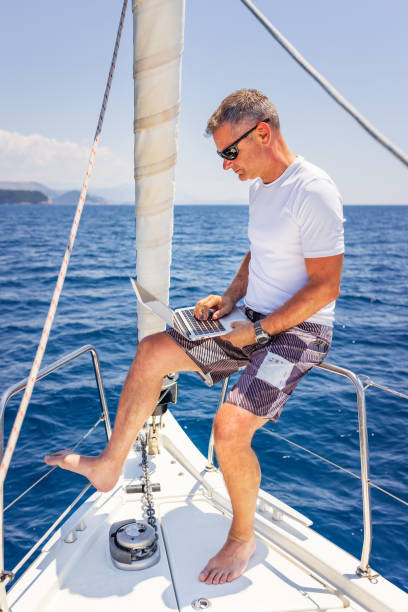 istock Businessman with laptop on sailboat 1407530561