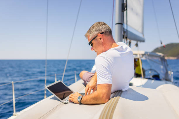 istock Businessman with laptop on sailboat 1407530611