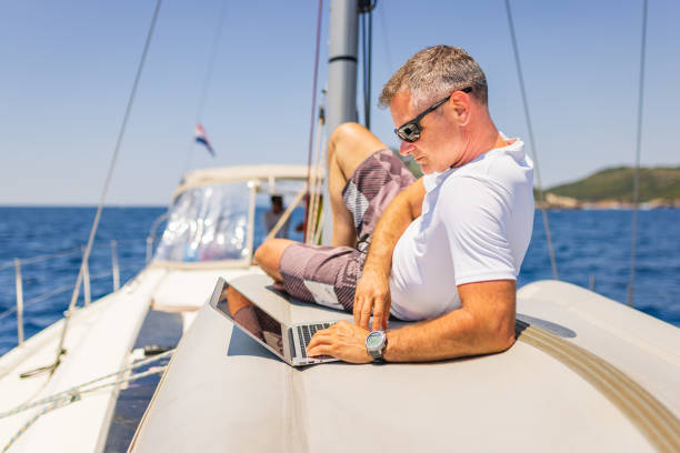 istock Businessman with laptop on sailboat 1407530620