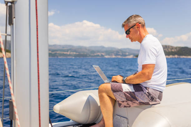 istock Businessman with laptop on sailboat 1407530664
