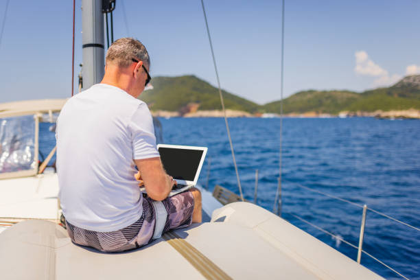 istock Businessman with laptop on sailboat 1407530688