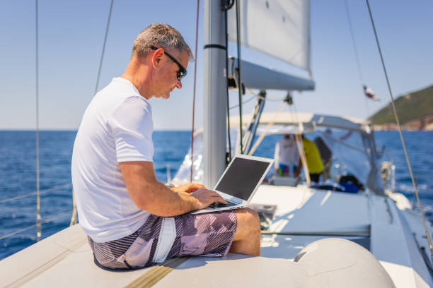 istock Businessman with laptop on sailboat 1407530701