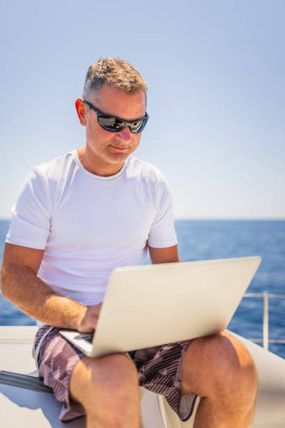 istock Businessman with laptop on sailboat 1407530722