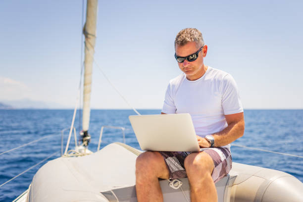 istock Businessman with laptop on sailboat 1407530741