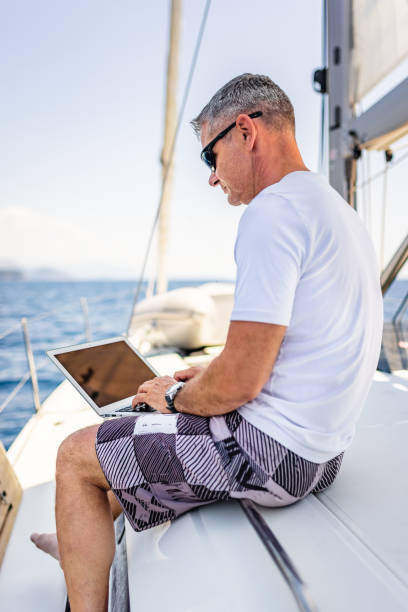 istock Businessman with laptop on sailboat 1407530770