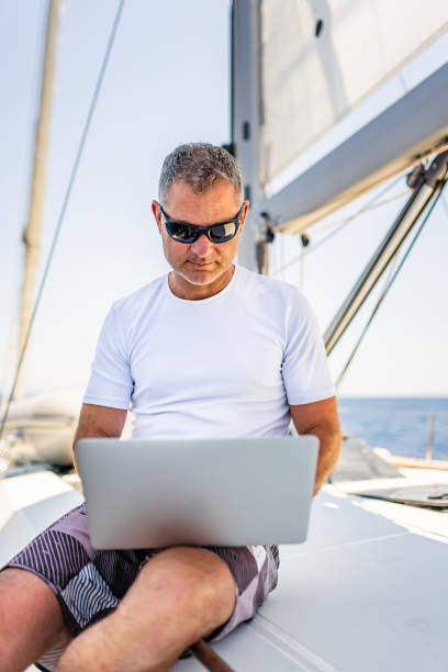 istock Businessman with laptop on sailboat 1407530783