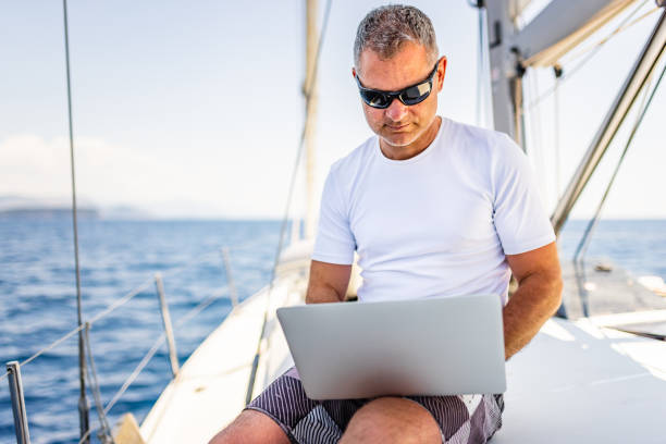istock Businessman with laptop on sailboat 1407530790