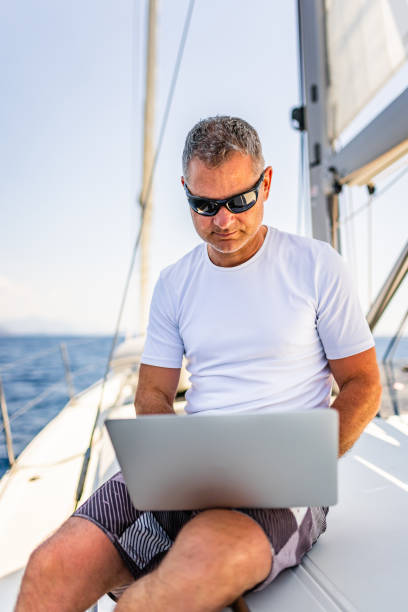 istock Businessman with laptop on sailboat 1407530794