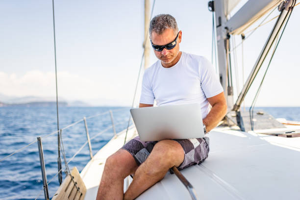 istock Businessman with laptop on sailboat 1407530809