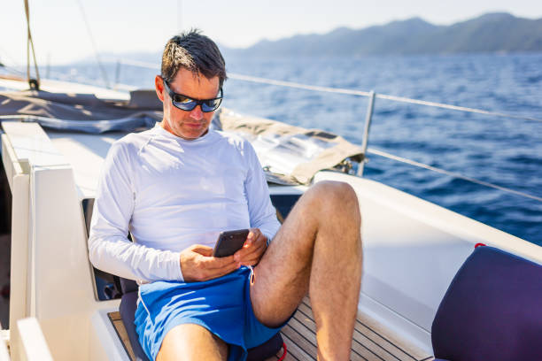 istock Businessman with smart phone on sailboat 1407530893