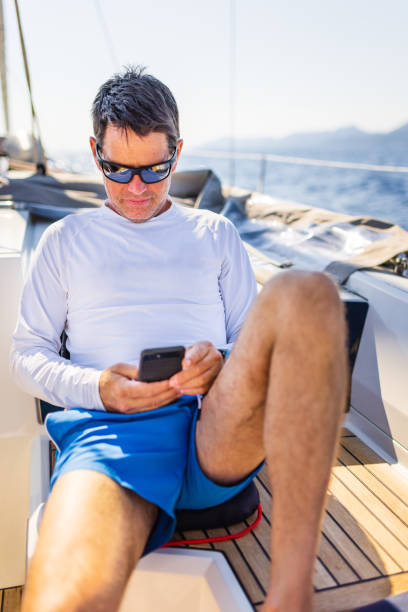 istock Businessman with smart phone on sailboat 1407531411