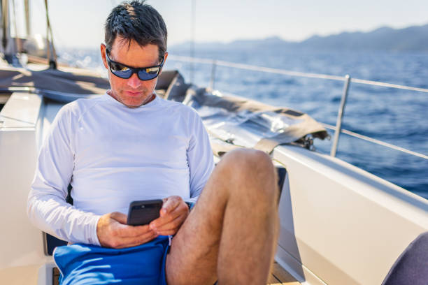 istock Businessman with smart phone on sailboat 1407531431