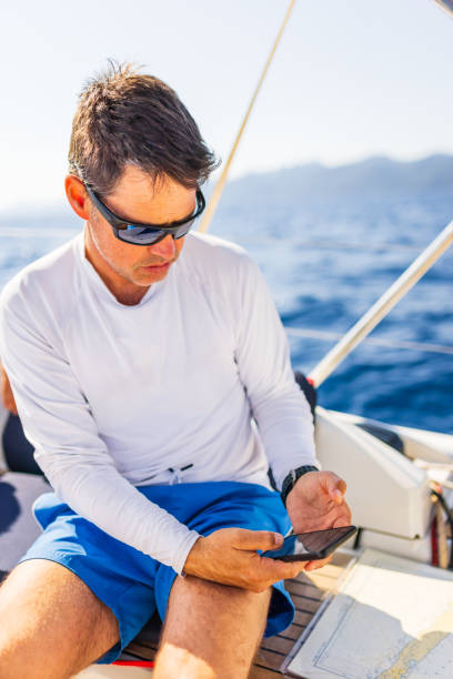 istock Businessman with smart phone on sailboat 1407531453