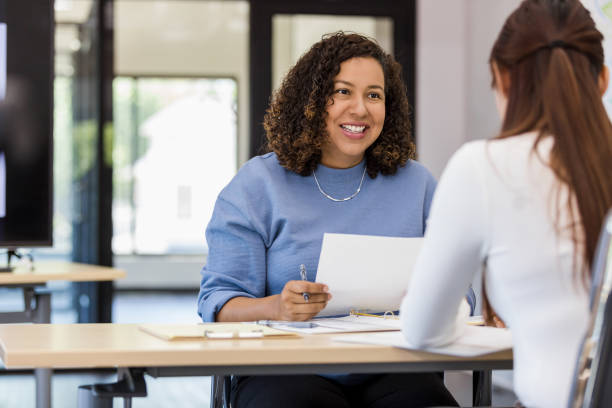 el gerente de la oficina habla con el nuevo pasante - interview meeting business women fotografías e imágenes de stock