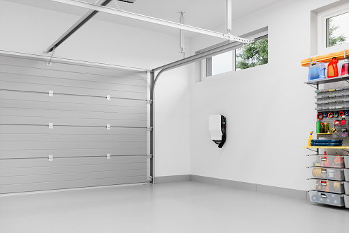 Interior of an empty modern residential garage with EV charger.