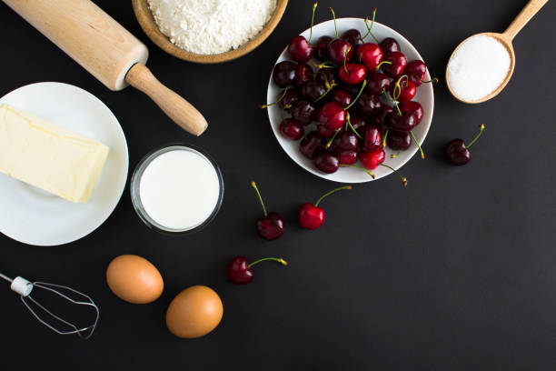 istock Top view of ingredients for making cherry pie or cake on the black background. Copy space. 1407541700
